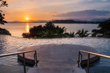 Tayland 'da lüks bir tatilde yüzme havuzu, körfeze bakan gün batımını izleyen havuz.