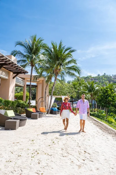 Paar man en vrouw middelbare leeftijd in het zwembad op een luxe vakantie in Thailand, mannen en Aziatische vrouw in het zwembad kijken uit over de baai kijken zonsondergang — Stockfoto