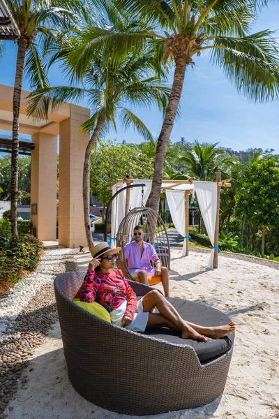 Coppia uomo e donna di mezza età in piscina in una vacanza di lusso in Thailandia, uomini e donne asiatiche in piscina con vista sulla baia guardando il tramonto — Foto Stock