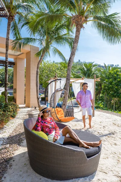 Paar man en vrouw middelbare leeftijd in het zwembad op een luxe vakantie in Thailand, mannen en Aziatische vrouw in het zwembad kijken uit over de baai kijken zonsondergang — Stockfoto