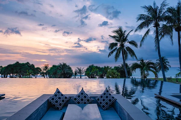 Assistindo ao pôr do sol na piscina infinita em umas férias de luxo na Tailândia, assistindo ao pôr do sol na borda de uma piscina na Tailândia — Fotografia de Stock