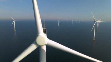 Sabahın erken saatlerinde rüzgar türbinleri, Hollanda 'da rüzgar değirmeni parkı. Hava manzaralı rüzgar türbini, rüzgar parkı batı manzaralı drone manzaralı IJsselmeer gölündeki bir yel değirmeni çiftliği.