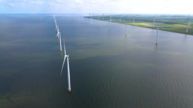 Sabahın erken saatlerinde rüzgar türbinleri, Hollanda 'da rüzgar değirmeni parkı. Hava manzaralı rüzgar türbini, rüzgar parkı batı manzaralı drone manzaralı IJsselmeer gölündeki bir yel değirmeni çiftliği.