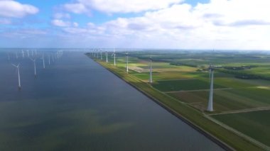 Sabahın erken saatlerinde rüzgar türbinleri, Hollanda 'da rüzgar değirmeni parkı. Hava manzaralı rüzgar türbini, rüzgar parkı batı manzaralı drone manzaralı IJsselmeer gölündeki bir yel değirmeni çiftliği.
