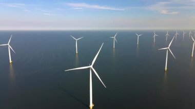 Sabahın erken saatlerinde rüzgar türbinleri, Hollanda 'da rüzgar değirmeni parkı. Hava manzaralı rüzgar türbini, rüzgar parkı batı manzaralı drone manzaralı IJsselmeer gölündeki bir yel değirmeni çiftliği.