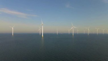 Sabahın erken saatlerinde rüzgar türbinleri, Hollanda 'da rüzgar değirmeni parkı. Hava manzaralı rüzgar türbini, rüzgar parkı batı manzaralı drone manzaralı IJsselmeer gölündeki bir yel değirmeni çiftliği.