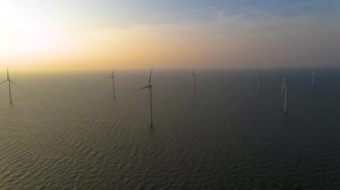 Sabahın erken saatlerinde rüzgar türbinleri, Hollanda 'da rüzgar değirmeni parkı. Hava manzaralı rüzgar türbini, rüzgar parkı batı manzaralı drone manzaralı IJsselmeer gölündeki bir yel değirmeni çiftliği.