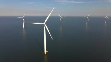 Sabahın erken saatlerinde rüzgar türbinleri, Hollanda 'da rüzgar değirmeni parkı. Hava manzaralı rüzgar türbini, rüzgar parkı batı manzaralı drone manzaralı IJsselmeer gölündeki bir yel değirmeni çiftliği.