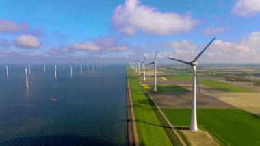 Sabahın erken saatlerinde rüzgar türbinleri, Hollanda 'da rüzgar değirmeni parkı. Hava manzaralı rüzgar türbini, rüzgar parkı batı manzaralı drone manzaralı IJsselmeer gölündeki bir yel değirmeni çiftliği.