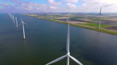 Sabahın erken saatlerinde rüzgar türbinleri, Hollanda 'da rüzgar değirmeni parkı. Hava manzaralı rüzgar türbini, rüzgar parkı batı manzaralı drone manzaralı IJsselmeer gölündeki bir yel değirmeni çiftliği.