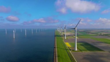 Sabahın erken saatlerinde rüzgar türbinleri, Hollanda 'da rüzgar değirmeni parkı. Hava manzaralı rüzgar türbini, rüzgar parkı batı manzaralı drone manzaralı IJsselmeer gölündeki bir yel değirmeni çiftliği.
