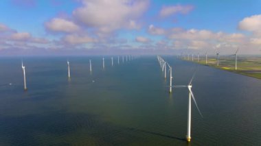 Sabahın erken saatlerinde rüzgar türbinleri, Hollanda 'da rüzgar değirmeni parkı. Hava manzaralı rüzgar türbini, rüzgar parkı batı manzaralı drone manzaralı IJsselmeer gölündeki bir yel değirmeni çiftliği.