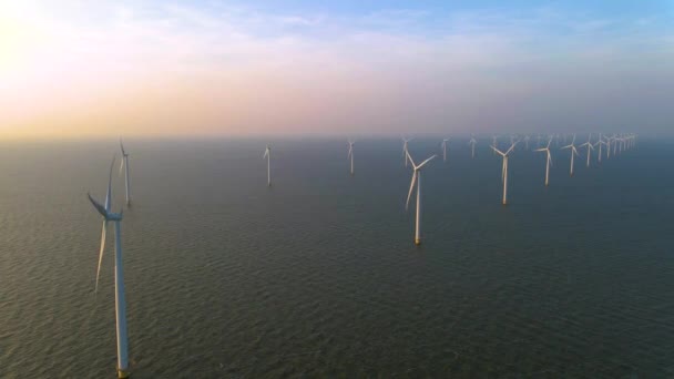 Wind turbines in the early morning, wind mill park in the Netherlands. Wind turbine from aerial view, Drone view at windpark westermeerdijk a windmill farm in the lake IJsselmeer the biggest in the — Stock Video