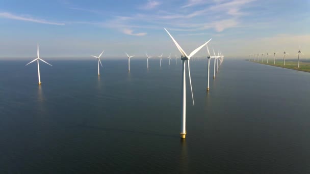 Windturbines in de vroege ochtend, windmolenpark in Nederland. Windturbine vanuit de lucht, Uitzicht op Drone bij windpark westermeerdijk een windmolenpark in het IJsselmeer de grootste in de — Stockvideo