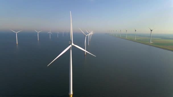 Windturbines in de vroege ochtend, windmolenpark in Nederland. Windturbine vanuit de lucht, Uitzicht op Drone bij windpark westermeerdijk een windmolenpark in het IJsselmeer de grootste in de — Stockvideo