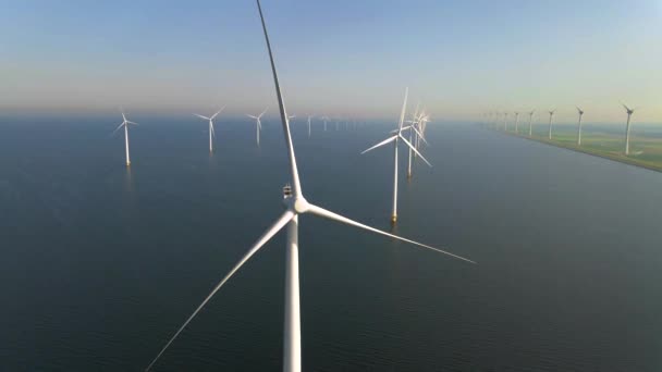 Windturbines in de vroege ochtend, windmolenpark in Nederland. Windturbine vanuit de lucht, Uitzicht op Drone bij windpark westermeerdijk een windmolenpark in het IJsselmeer de grootste in de — Stockvideo