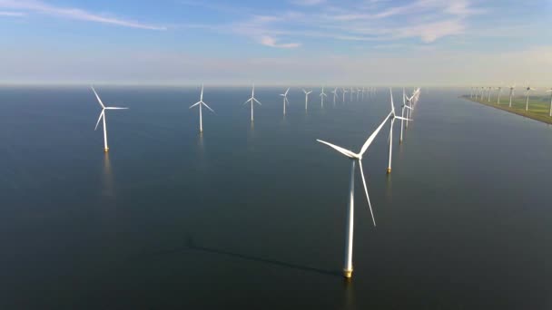 Turbinas eólicas en la madrugada, parque de molinos de viento en los Países Bajos. aerogenerador desde la vista aérea, Drone vista en el parque eólico westermeerdijk una granja de molinos de viento en el lago IJsselmeer el más grande de la — Vídeo de stock
