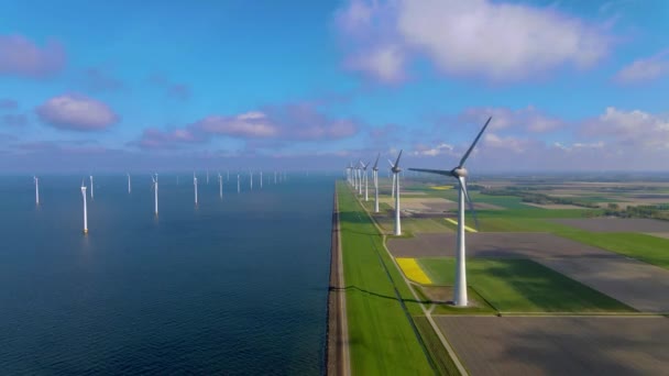 Windturbines in de vroege ochtend, windmolenpark in Nederland. Windturbine vanuit de lucht, Uitzicht op Drone bij windpark westermeerdijk een windmolenpark in het IJsselmeer de grootste in de — Stockvideo