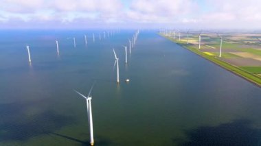 Sabahın erken saatlerinde rüzgar türbinleri, Hollanda 'da rüzgar değirmeni parkı. Hava manzaralı rüzgar türbini, rüzgar parkı batı manzaralı drone manzaralı IJsselmeer gölündeki bir yel değirmeni çiftliği.