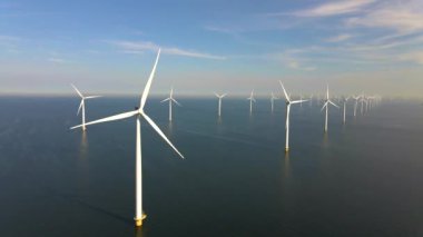 Sabahın erken saatlerinde rüzgar türbinleri, Hollanda 'da rüzgar değirmeni parkı. Hava manzaralı rüzgar türbini, rüzgar parkı batı manzaralı drone manzaralı IJsselmeer gölündeki bir yel değirmeni çiftliği.