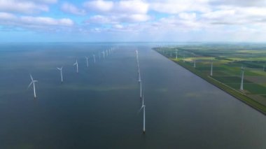 Sabahın erken saatlerinde rüzgar türbinleri, Hollanda 'da rüzgar değirmeni parkı. Hava manzaralı rüzgar türbini, rüzgar parkı batı manzaralı drone manzaralı IJsselmeer gölündeki bir yel değirmeni çiftliği.