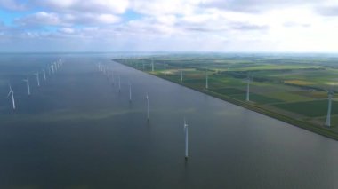 Sabahın erken saatlerinde rüzgar türbinleri, Hollanda 'da rüzgar değirmeni parkı. Hava manzaralı rüzgar türbini, rüzgar parkı batı manzaralı drone manzaralı IJsselmeer gölündeki bir yel değirmeni çiftliği.