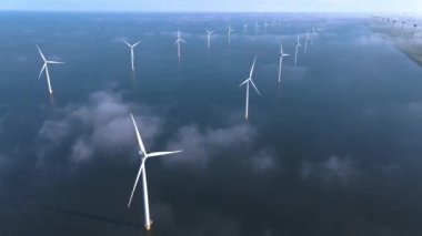 Sabahın erken saatlerinde rüzgar türbinleri, Hollanda 'da rüzgar değirmeni parkı. Hava manzaralı rüzgar türbini, rüzgar parkı batı manzaralı drone manzaralı IJsselmeer gölündeki bir yel değirmeni çiftliği.