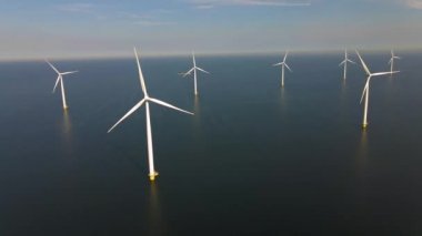 Sabahın erken saatlerinde rüzgar türbinleri, Hollanda 'da rüzgar değirmeni parkı. Hava manzaralı rüzgar türbini, rüzgar parkı batı manzaralı drone manzaralı IJsselmeer gölündeki bir yel değirmeni çiftliği.