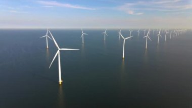 Sabahın erken saatlerinde rüzgar türbinleri, Hollanda 'da rüzgar değirmeni parkı. Hava manzaralı rüzgar türbini, rüzgar parkı batı manzaralı drone manzaralı IJsselmeer gölündeki bir yel değirmeni çiftliği.