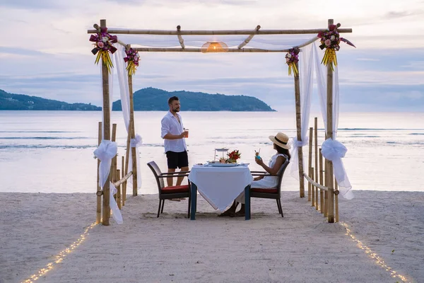Dîner romantique sur la plage à Phuket en Thaïlande, couple homme et femme d'âge moyen femme asiatique et homme européen dînant sur la plage en Thaïlande pendant le coucher du soleil — Photo