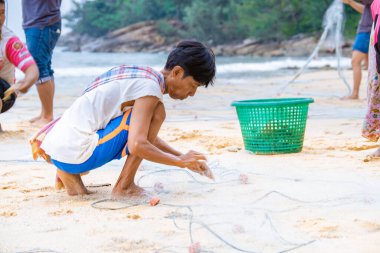 Phuket Tayland, Naithonbury sahilindeki yerel balıkçılar balık ağlarını boşaltıyorlar, Taylandlı balıkçılar sahilde.