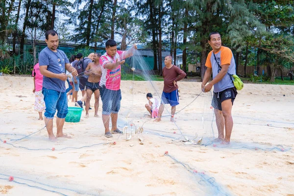 Phuket Tayland, Naithonbury sahilindeki yerel balıkçılar balık ağlarını boşaltıyorlar, Taylandlı balıkçılar sahilde.