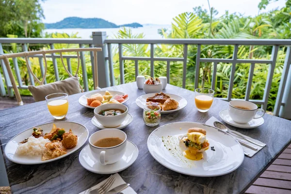 海を見下ろす朝食テーブル、コーヒーパンのクロワッサンとフルーツプラッタと朝食。 — ストック写真