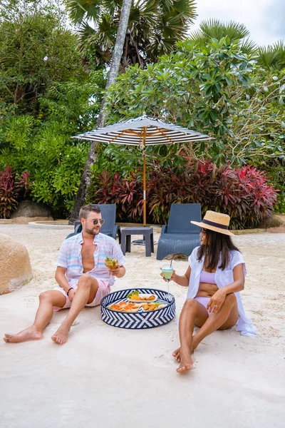 Cocktail am Strand mit Mittagessen und Snacks, Mojito-Cocktail und blauem Curaçao am Strand mit Surfbrett — Stockfoto