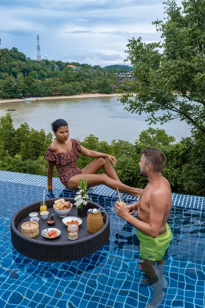Ζευγάρι άνδρας και γυναίκα στην πισίνα που παίρνουν πλωτό πρωινό, άνδρες και κορίτσι που παίρνουν πρωινό στην πισίνα — Φωτογραφία Αρχείου
