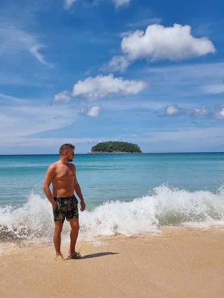 Playa de Kata Phuket Tailandia, youn hombre caminando en la playa en natación corta — Foto de Stock
