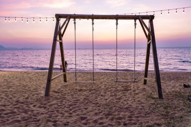 Na Jomtien Sahili Pattaya Tayland, gün batımında tropik sahilde salıncak