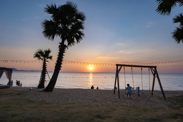 Na Jomtien Sahili Pattaya Tayland, gün batımında tropik sahilde salıncak