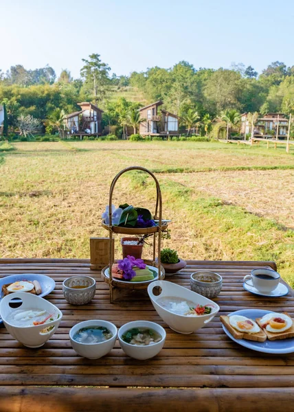 Kuzey Tayland 'daki İskandinav stil kulübesi Tayland' daki pirinç tarlalarına bakıyor, yeşil pirinç tarlalarına.