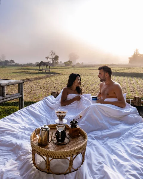 Paar man en vrouw in bed kijken uit over de rijstvelden in Noord-Thailand Nan — Stockfoto