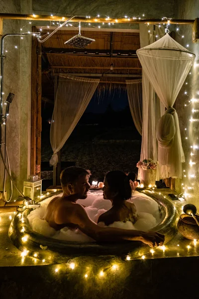 Couple in bathroom in bath tub at night with christmas lights, man and woman mid age having romantic night in bath tub in Nan Thailand — Foto de Stock