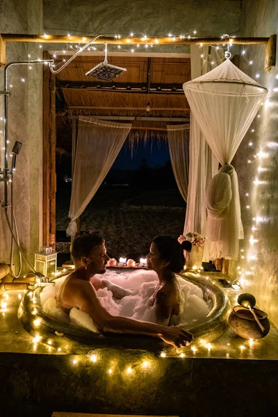 Pareja en baño en bañera por la noche con luces de Navidad, hombre y mujer de mediana edad teniendo noche romántica en bañera en Nan Tailandia —  Fotos de Stock