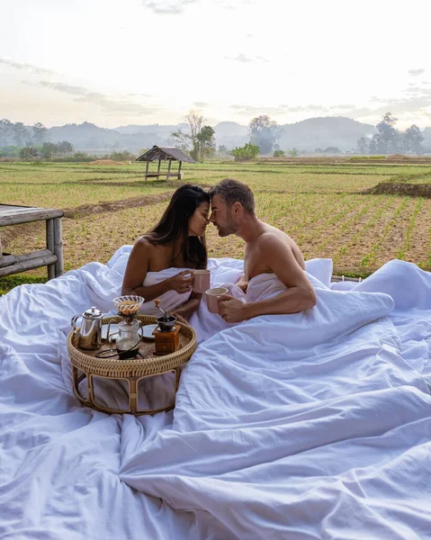Couple man and woman in bed looking out over the rice paddies field in Northern Thailand Nan — стокове фото