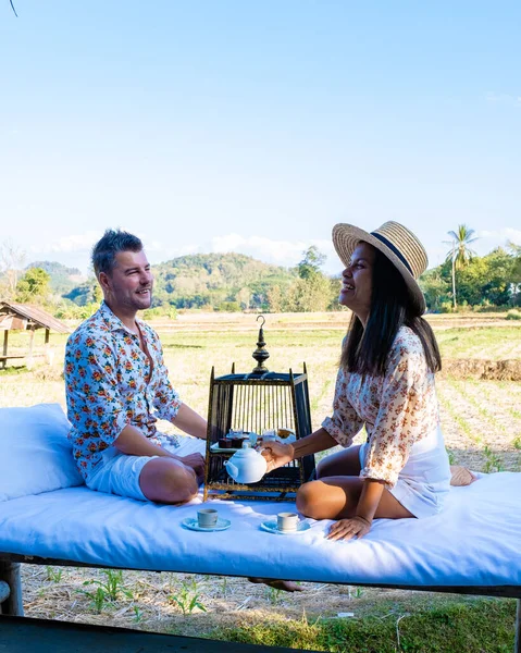 Couple man and woman on vacation in Nan Thailand drinking coffee and high tea with a look over the countryside of Nan Thailand — 스톡 사진