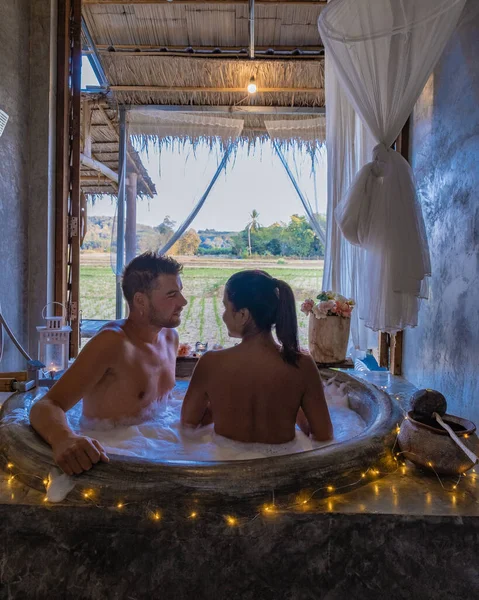 Ζευγάρι στο μπάνιο στην μπανιέρα το βράδυ με χριστουγεννιάτικα φώτα, άνδρας και γυναίκα μέσης ηλικίας που έχουν ρομαντική νύχτα στην μπανιέρα στη Ναν Ταϊλάνδη — Φωτογραφία Αρχείου