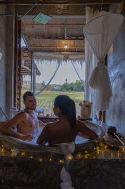 Geceleyin banyoda, banyoda, noel ışıklarıyla, orta yaşlı bir adam ve kadın, Nan Tayland 'da küvette romantik bir gece geçiriyorlar.