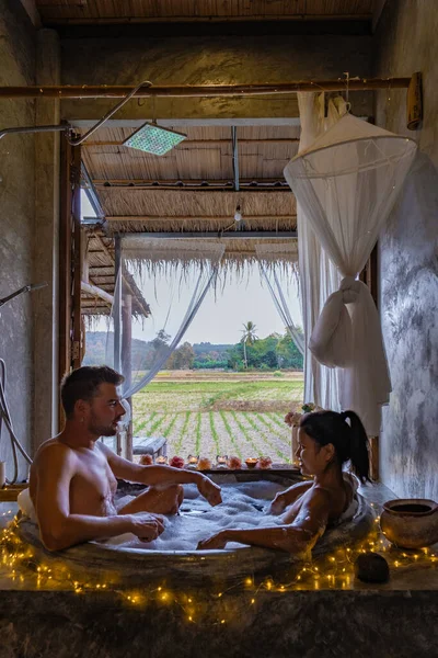 Paar in badkamer in bad 's nachts met kerstverlichting, man en vrouw van middelbare leeftijd met romantische nacht in bad in Nan Thailand — Stockfoto