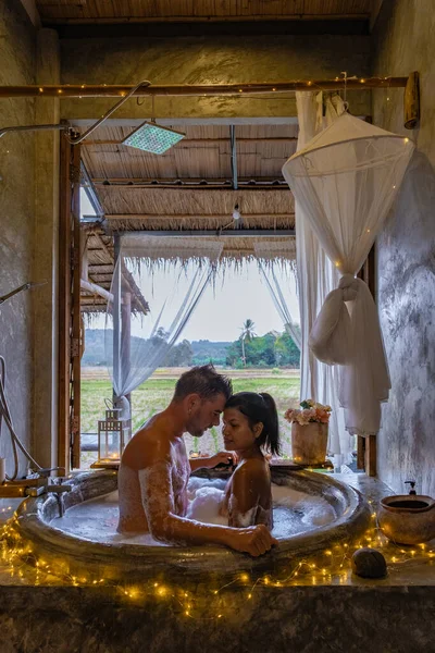 Paar in badkamer in bad 's nachts met kerstverlichting, man en vrouw van middelbare leeftijd met romantische nacht in bad in Nan Thailand — Stockfoto