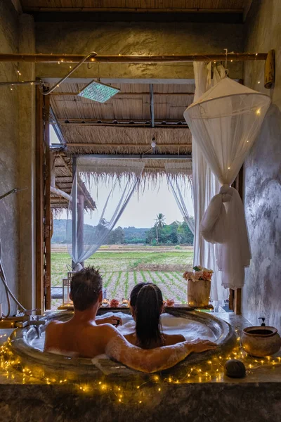 Couple in bathroom in bath tub at night with christmas lights, man and woman mid age having romantic night in bath tub in Nan Thailand — Photo