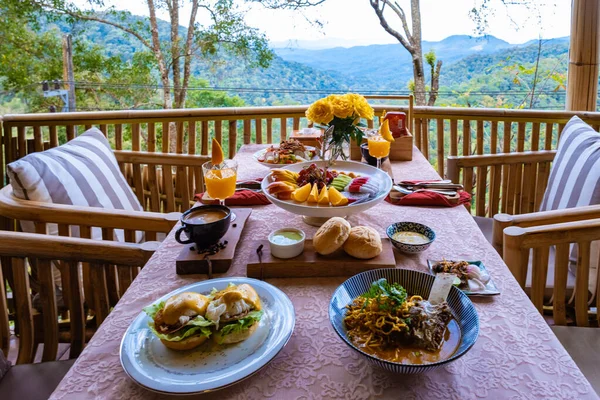Top view of a luxury breakfast in the mountains of Chiang Mai Thailand, luxury breakfast with Chiang Mai curry noodle soup or Khao soi gai and fruits and coffee — Fotografia de Stock